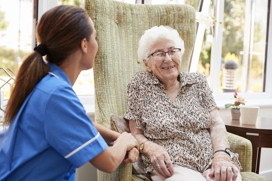 Hospice patient at home smiling and talking with nurse