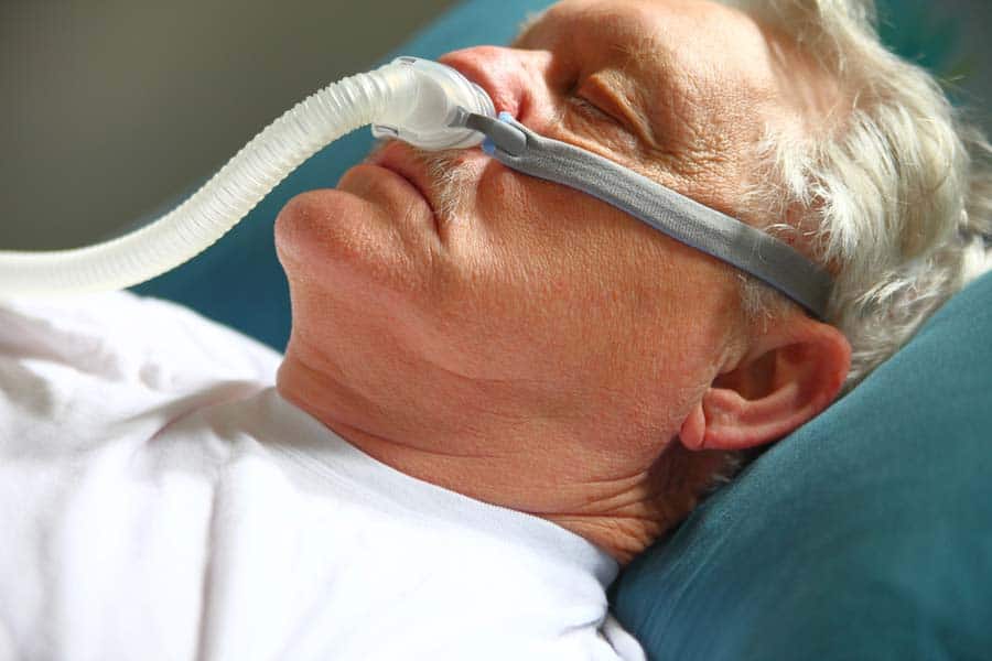 man sleeping with a CPAP on