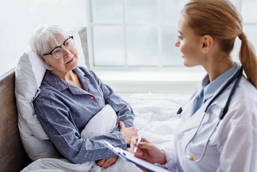 Female Doctor discussing pain management with an Elderly patient.