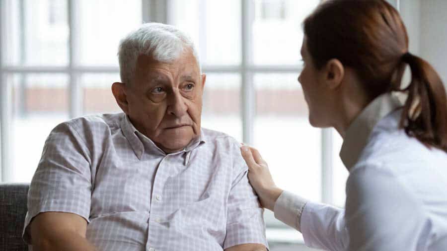 Female doctor comforting upset older patient